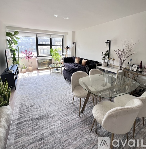 A living room with a glass table and white chairs.