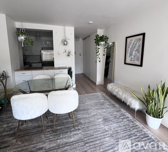 A modern living room with a glass table and white chairs.