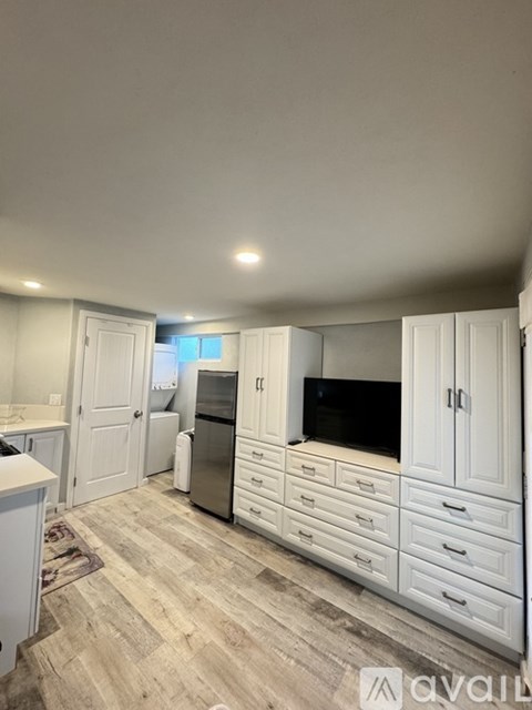 A kitchen with white cabinets and a wooden floor.