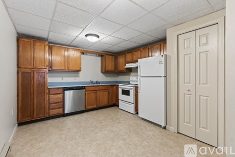 A kitchen with wooden cabinets and a white refrigerator.
