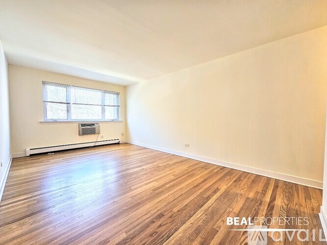 A room with wooden flooring and a window.