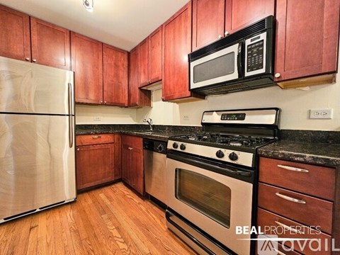 A kitchen with wooden cabinets and a black stove top oven.