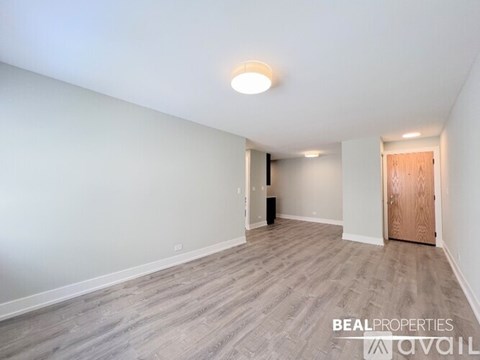 A spacious room with a door on the right and a light on the ceiling.