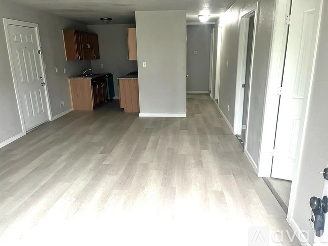 A room with wooden flooring and white walls.