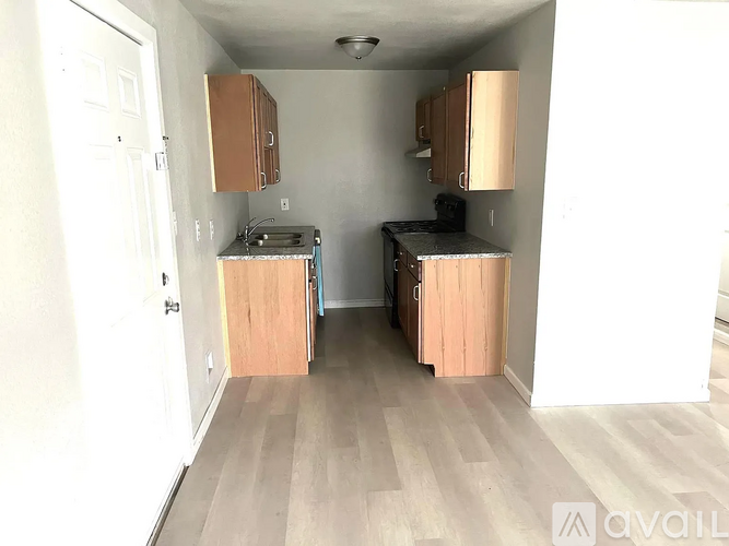 A kitchen with wooden cabinets and a black countertop.