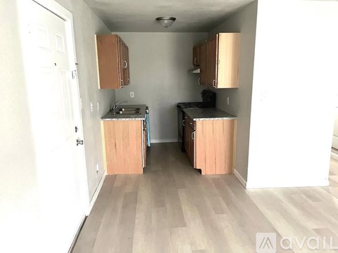 A kitchen with wooden cabinets and a black countertop.