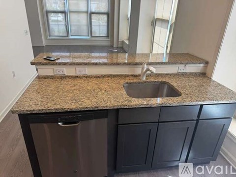 A kitchen counter with a sink and a dishwasher.