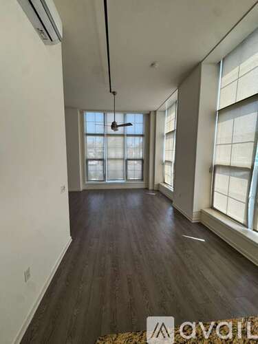 A room with wooden floors and large windows.