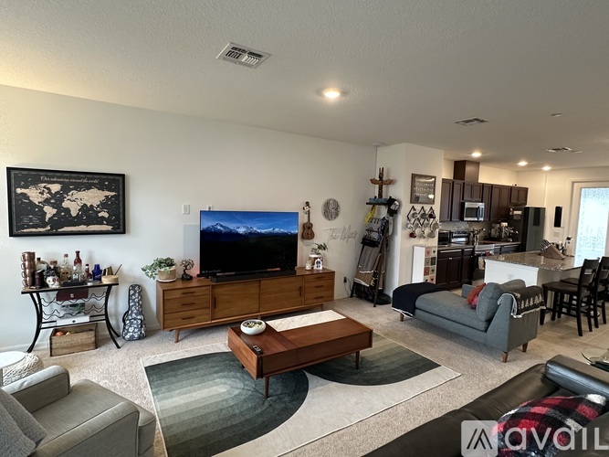 A living room with a grey couch, a coffee table, and a television.
