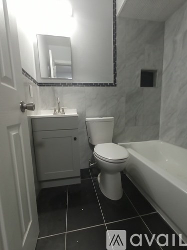 A bathroom with a toilet, sink, and bathtub.