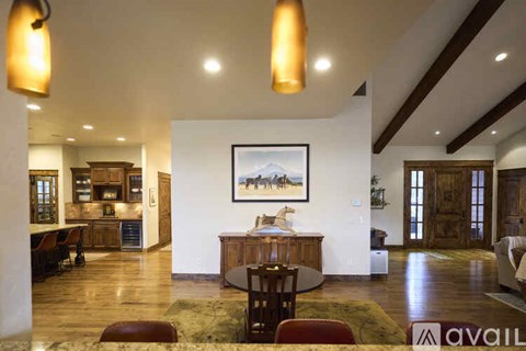 A living room with a painting of a mountain scene on the wall.