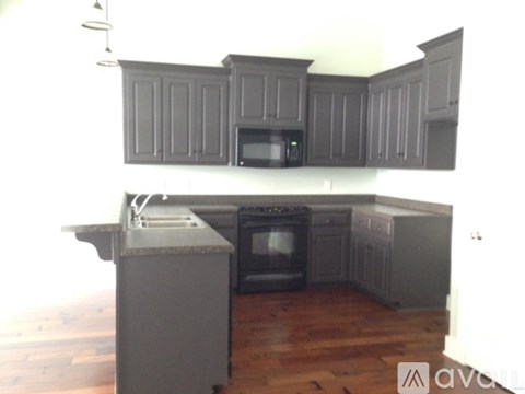 A kitchen with wooden cabinets and a grey island.