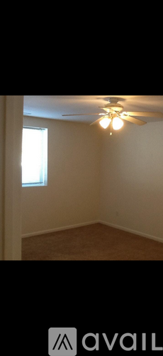 A room with a ceiling fan and a window.