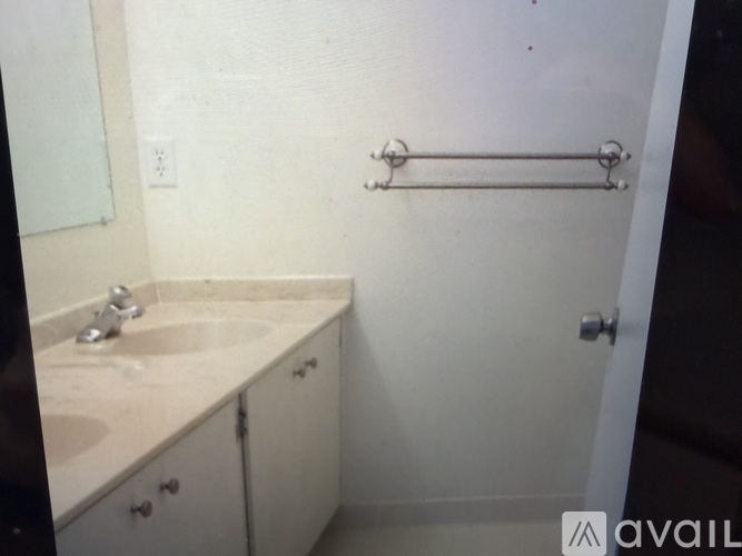 A bathroom with a sink, mirror, and towel rack.