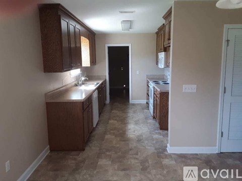 A kitchen with brown cabinets and a black door.