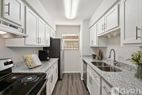A kitchen with white cabinets and a black stove top.