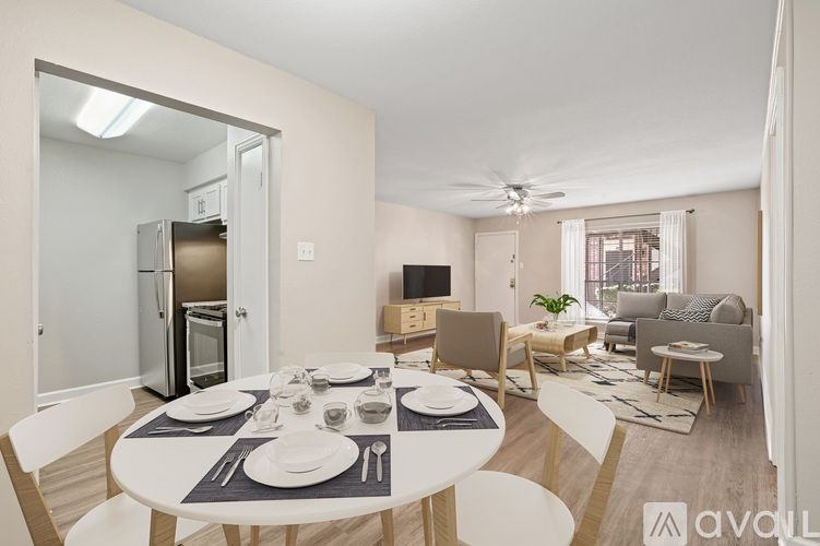 A modern dining room with a white table set for two.