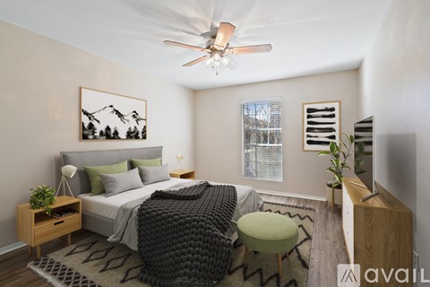 A bedroom with a bed, a chair, and a ceiling fan.