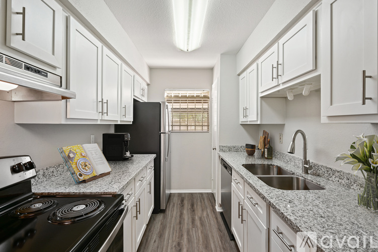 A kitchen with white cabinets and a black stove top.
