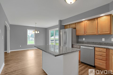 A kitchen with wooden cabinets and a granite countertop.