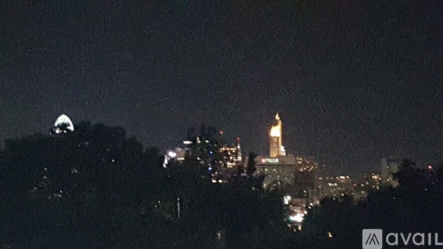 A cityscape at night with a prominent tower lit up.