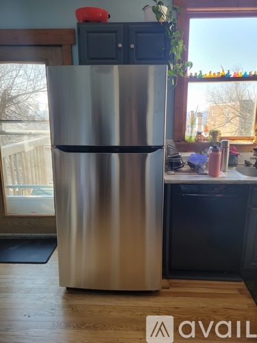 A stainless steel refrigerator stands in a kitchen.