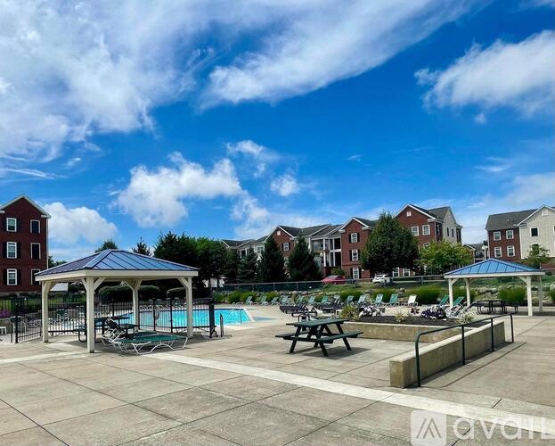 A sunny day at the outdoor pool area with picnic tables and pavilions.