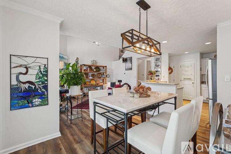 A modern dining room with a white table and chairs.