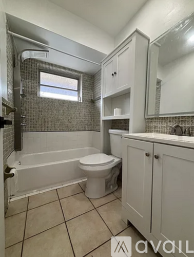 A bathroom with a toilet, tub, and sink.