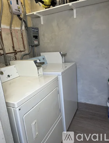 A white washing machine is on a shelf in a room.