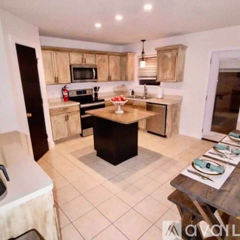A kitchen with a table and chairs in the middle of the room.