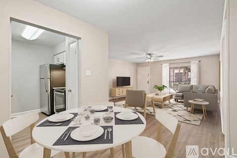 A modern dining room with a white table set for two.