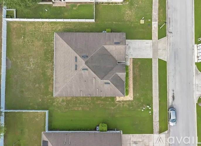 A large grey building with a triangular roof sits in a grassy field.