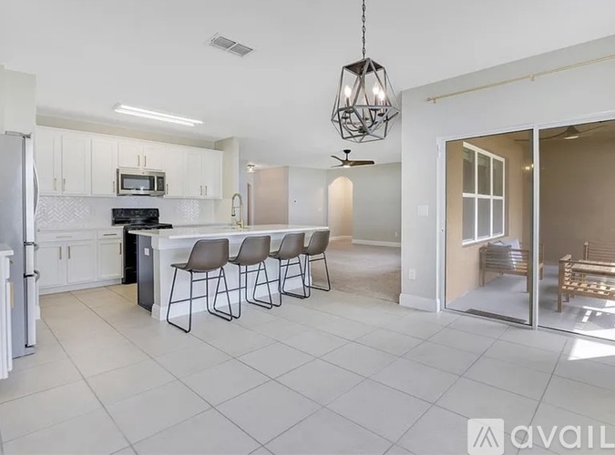 A kitchen with white cabinets and a black stove top oven.