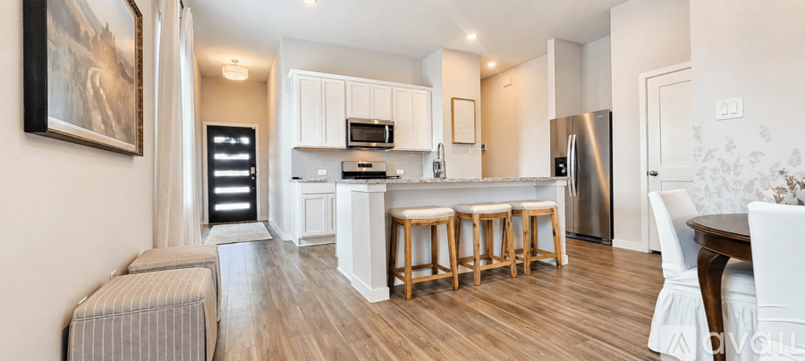 A kitchen with white cabinets and a wooden floor.