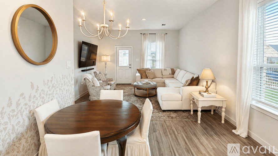 A living room with a wooden table and white chairs.