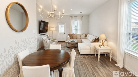 A living room with a wooden table and white chairs.
