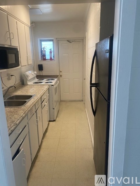 A kitchen with a refrigerator on the right side.