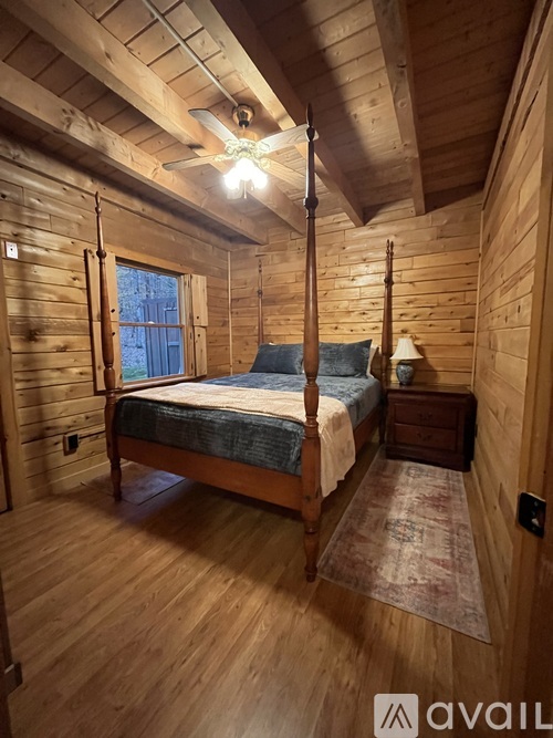 A bedroom with a bed, dresser, and window.