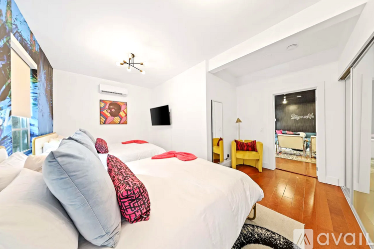 A bedroom with a large bed and a flat screen TV mounted on the wall.