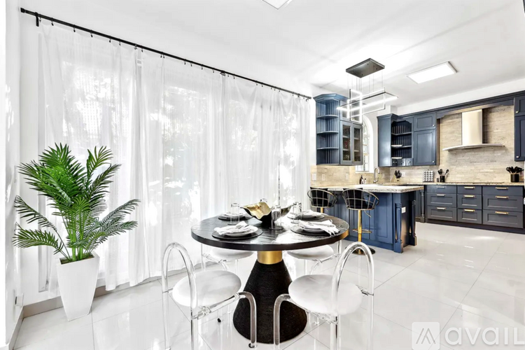 A modern kitchen with a dining table set for two.