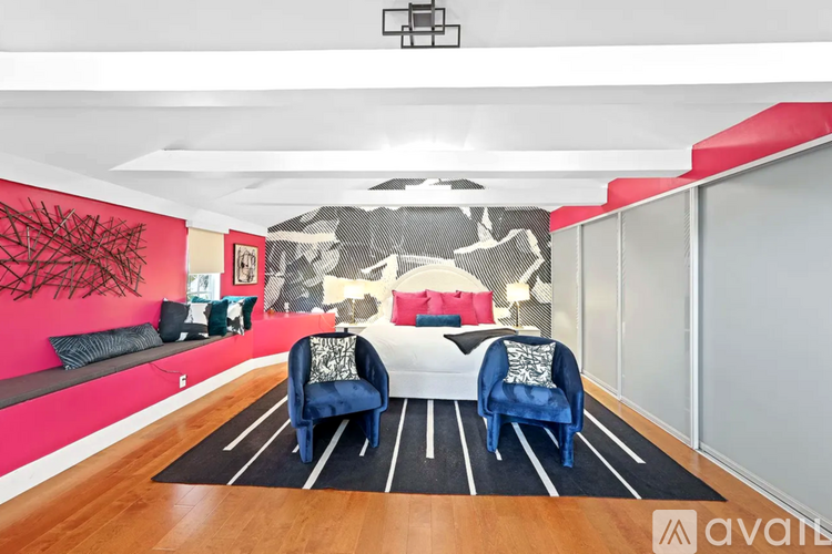 A living room with a white couch and a black and white mural on the wall.