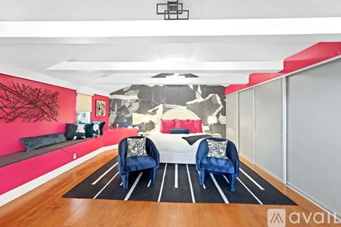 A living room with a white couch and a black and white mural on the wall.