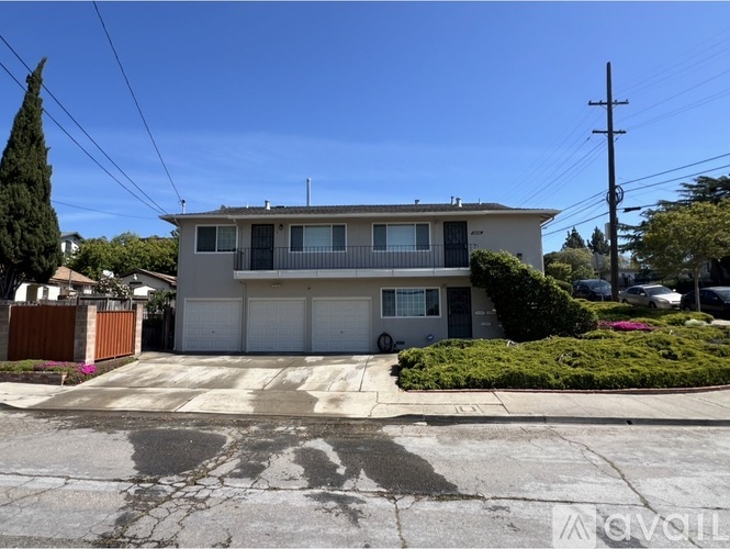 A two-story house with a garage is situated in a residential area.