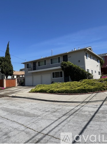 A two-story house with a white exterior and a brown fence.