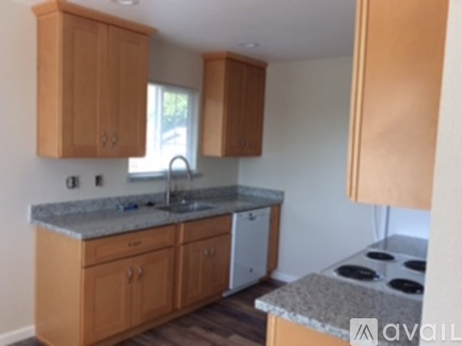 A kitchen with wooden cabinets and a granite counter top.