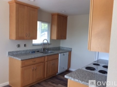 A kitchen with wooden cabinets and a granite counter top.
