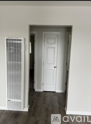A room with a white door and a white wall.