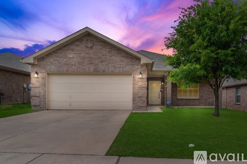 A house with a garage and a tree in front.
