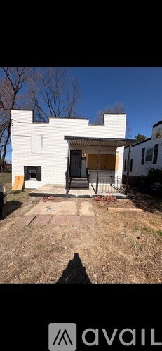 A white house with a black door and a shadow of a person in front of it.